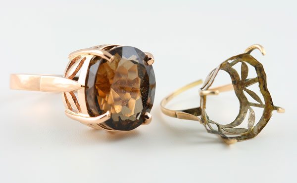 A smoky quartz ring beside the worn, empty setting it was rescued from