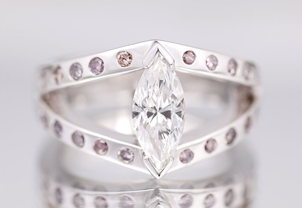 A large marquise diamond on a chevron band set with pink diamonds
