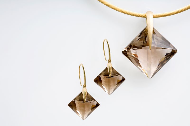 Square smoky quartz drop earrings and a matching pendant on a gold cable