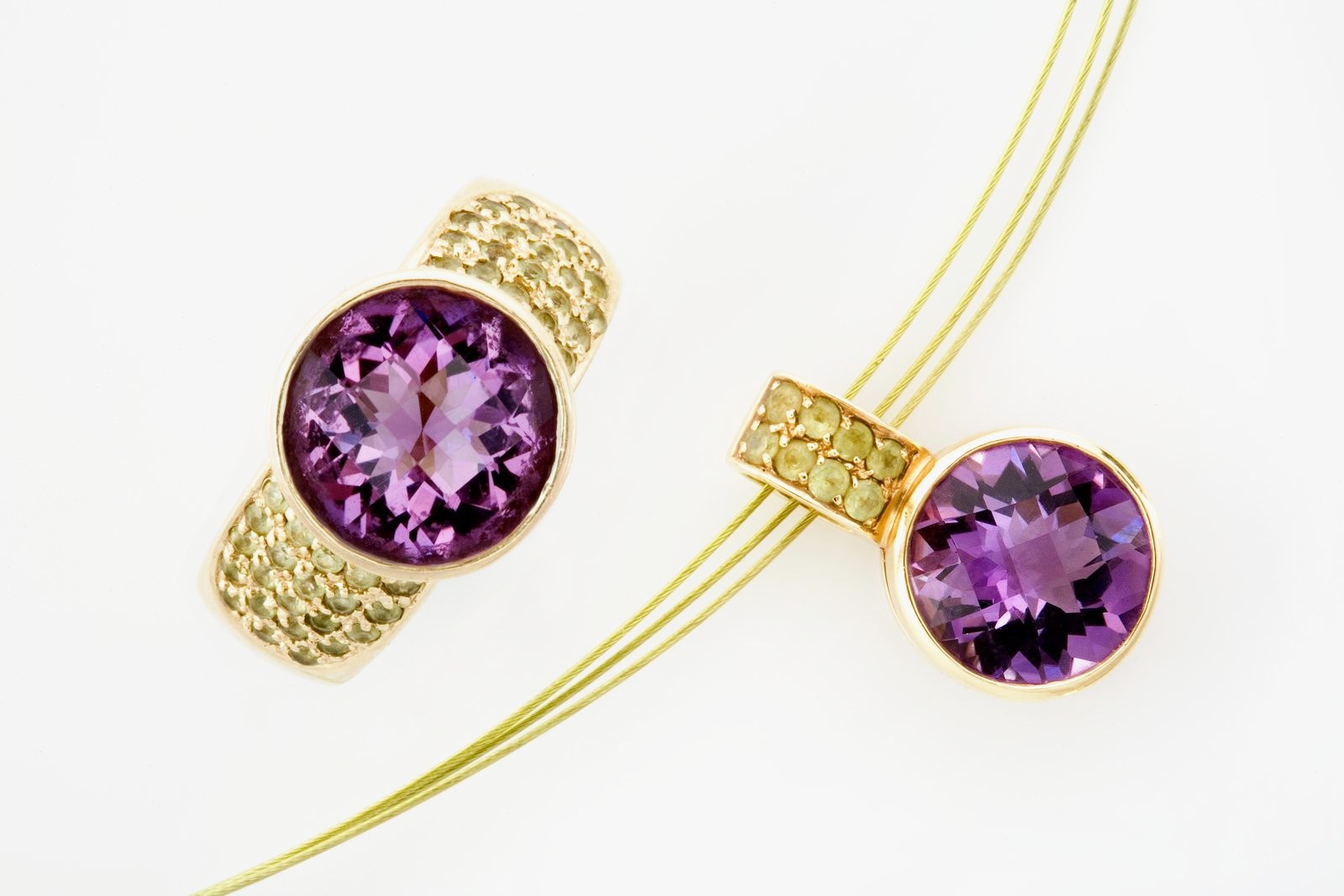 A round amethyst ring in textured gold with a matching pendant on a gold cable