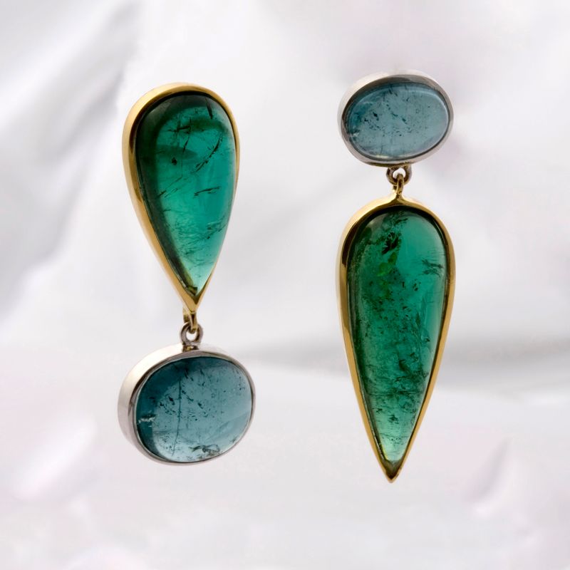 A pair of long drop earrings, each a blue-green tourmaline cabochon above a teardrop of darker green tourmaline