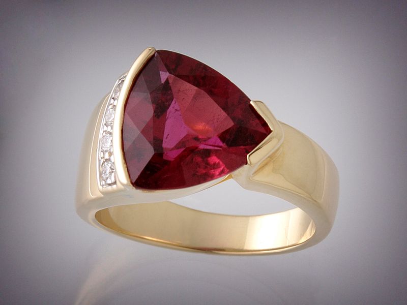 Ring with a large triangular pink rubellite tourmaline and a row of small diamonds, in yellow gold