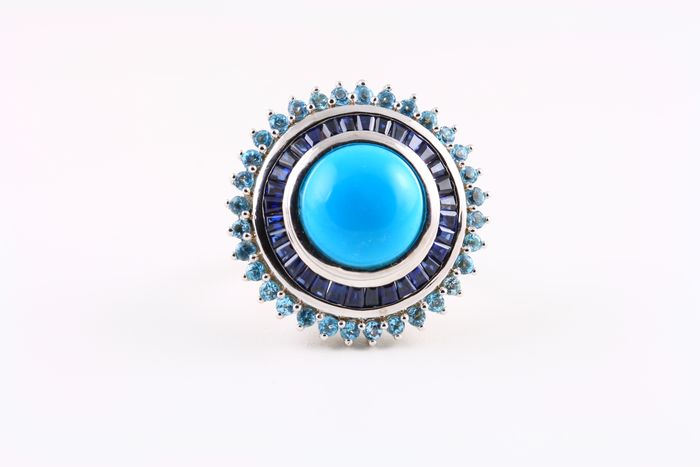 Turquoise halo ring: a Turquoise with blue Sapphires in 18 karat white gold