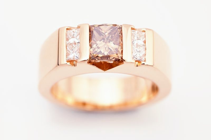 A rose gold band with a cushion-cut champagne diamond flanked by princess diamonds