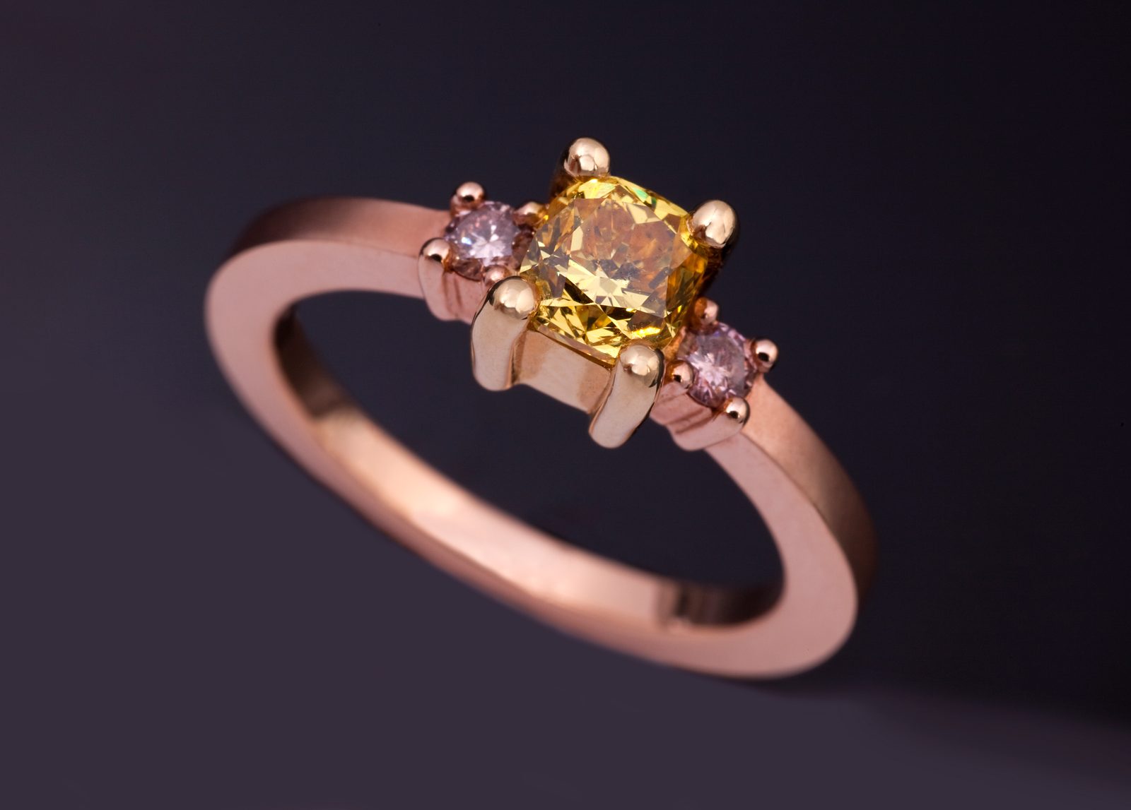 Yellow diamond ring: a yellow diamond with pink diamonds in 18 karat rose gold