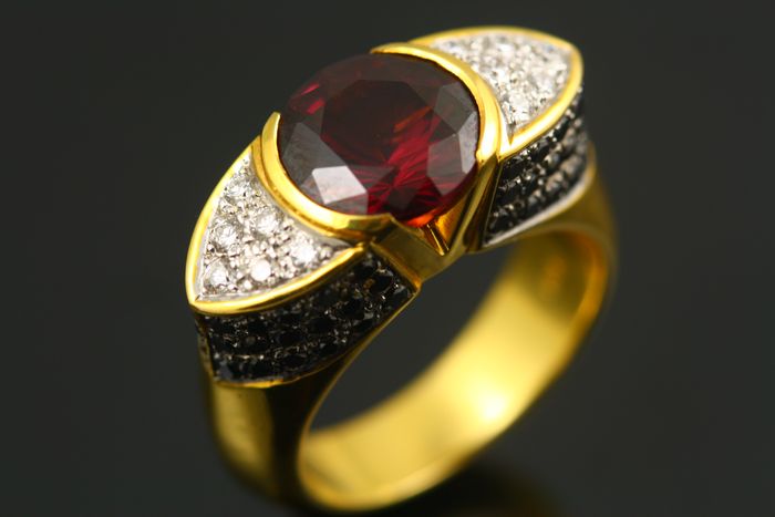 Rhodolite Garnet ring: a Rhodolite Garnet with colourless and black diamonds in 18 karat yellow gold
