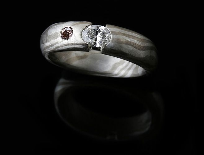 Mokume Gane and diamond ring: a white and a pink diamond set in a Mokume Gane ring