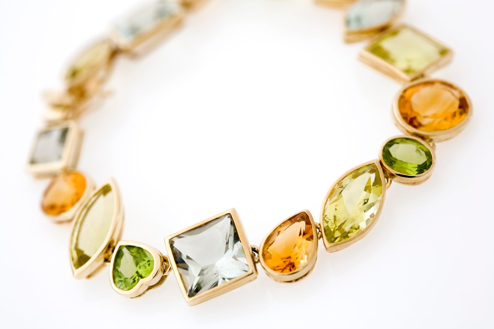 A bracelet of yellow, green and golden stones in mixed cuts linked in gold