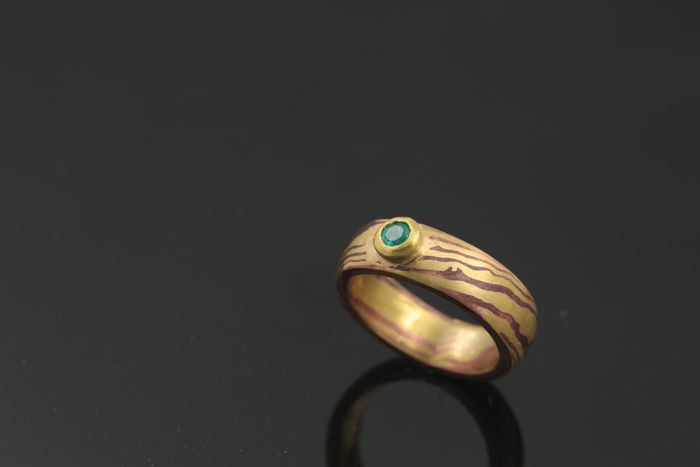 Emerald Mokume Gane ring: an Emerald set in a Mokume Gane ring