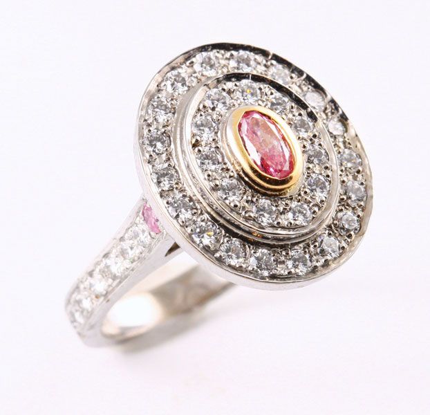 Pink diamond halo ring: a pink diamond with diamonds in 18 karat white and rose gold