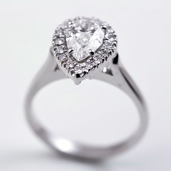 Pear diamond halo ring: a diamond with smaller diamonds in 18 karat white gold