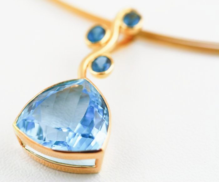 Topaz trillion pendant: a blue Topaz with Sapphires in 18 karat yellow gold