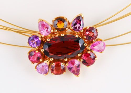 Garnet cluster pendant: a Garnet with pink Sapphires in 18 karat yellow gold