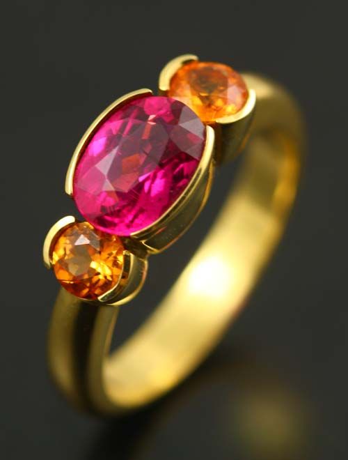Rubellite two-stone ring: a Rubellite Tourmaline with orange Sapphires in 18 karat yellow gold